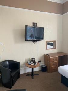 格拉斯哥Onslow bed and breakfast的酒店客房设有椅子、书桌和电视。