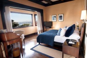 瓦尔帕莱索卡萨伊格拉斯酒店的一间卧室配有一张床、一张书桌和一个窗户。