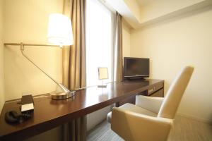 仙台里士满酒店普利米尔仙台站前的酒店客房配有带台灯和椅子的书桌