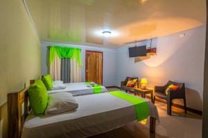 比加瓜Rio Celeste Springs Blue Lodge的一间带两张床的卧室和一间客厅
