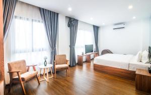 胡志明市Grand Lee Hotel的酒店客房,配有一张床和两把椅子