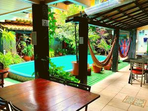 阿拉亚尔-杜卡布Villas Boas的一个带桌子和吊床的庭院和一个游泳池