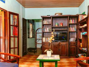 阿拉亚尔-杜卡布Villas Boas的一间带电视和书架的客厅