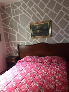 米兰肖邦酒店的卧室配有红色的床和墙上的绘画