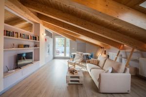 BussolenoLoft 29 mansardato con ampio terrazzo的客厅设有白色沙发和木制天花板。
