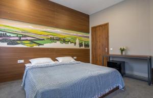 西格纳吉Hotel History • სასტუმრო ისტორია的卧室配有一张床,墙上挂有绘画作品