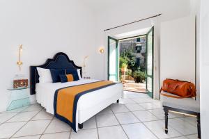阿马尔菲Amalfi Resort的一间带大床的卧室和一个阳台