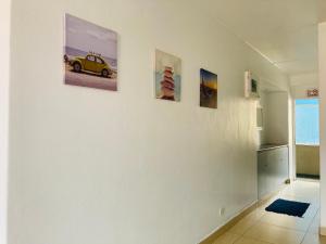 德班605 Tenbury Beach Apartment的墙上有三幅汽车画的房间