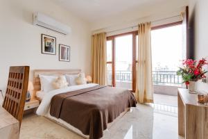 古尔冈Hostie Eva Dreams - Private 2 BHK Apartments near Artemis, Medanta, Fortis hospitals的一间带大床的卧室和一个阳台