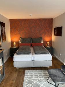 哈默尔恩Forsternest的一间卧室设有两张床,墙上装饰有橙色壁纸。