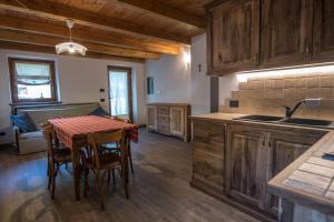 雷梅斯-诺特雷-达梅Chalet Mountain Relax - CIR 0001的厨房配有木制橱柜和桌椅