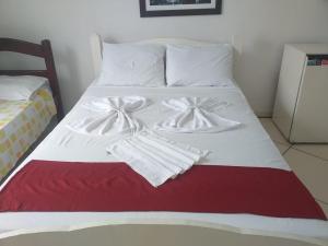 萨夸雷马Pousada Garota De Itauna的床上配有白色毯子和毛巾