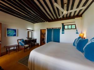 ShelaPeponi Hotel Lamu - Kenya的卧室配有白色的床和书桌