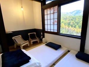 中津川市Guesthouse Nedoko的一间卧室设有两张床和大窗户
