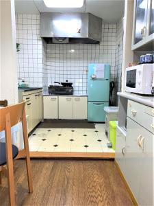 东京Tokyo Kakan的一间配备有蓝色冰箱的厨房和瓷砖地板