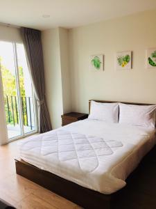 曼谷TEAK VILLA的卧室设有一张白色大床和一扇窗户。