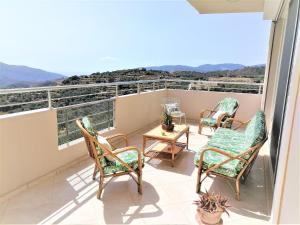 PrinésVilla Aeolus with private overflow, endless, heated pool的阳台配有桌椅,享有风景。