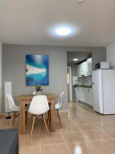 科拉雷侯Oasis Fuerteventura Beach Apartments的厨房配有桌子和白色冰箱。