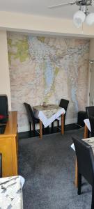 凯西克Babbling Brook Guesthouse的墙上有一张桌子和一张地图的房间