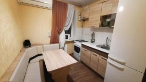 切尔诺莫斯克Двухкомнатная квартира 900м от моря отчетные док的一间带桌子和白色冰箱的小厨房