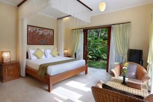 塞米亚克布阿巴厘岛别墅酒店的一间卧室配有一张床、一台电视和一张沙发