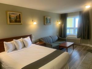 圣索弗尔-德斯蒙特Hotel and Suites Les Laurentides的配有一张床和一把椅子的酒店客房