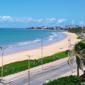 马塞约Flat em Hotel de Luxo beira mar da grife Ritz suítes com vista ampla para todo o mar da cruz das almas, jatiúca e ponta verde, com toda estrutura de um hotel lindo e arrojado, academia, piscina e muito mais, venha viver essa experiência incrível!的海滩上有人散步