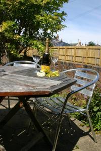 普雷斯蒂克Garden Cottage的一张桌子,上面放着一瓶葡萄酒和两杯酒