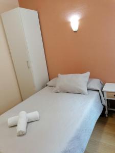卡塞雷斯Hostal Hernan Cortes的一间卧室配有一张床,上面有两条可移动的毛巾