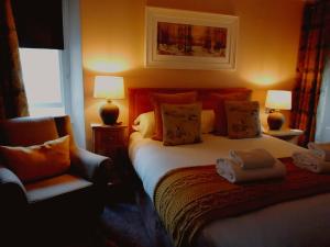 鲍内斯温德米尔奥克弗尔德别墅酒店的一间卧室配有一张带两盏灯和一把椅子的床。