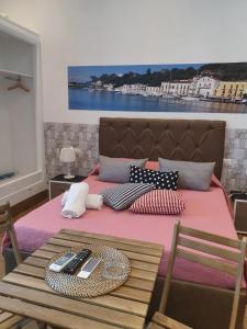 伊斯基亚Casa Vacanze Riva Destra的一张带粉色毯子和桌子的床