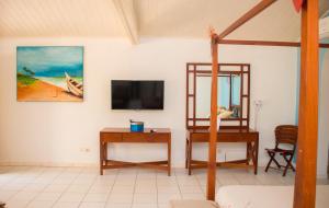 AzizacoueCasa Del Papa Resort & SPA的客房设有书桌和墙上的电视