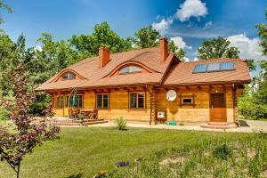 比亚沃维耶扎Dębowa Dziupla的屋顶上设有太阳能电池板的圆木房子
