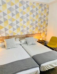 哈恩Pensión La Florida 19的一间卧室设有两张床和黄色的墙壁
