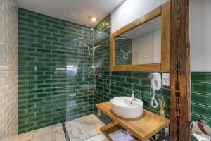 NepomukPivní Hotel的绿色瓷砖浴室设有水槽和镜子