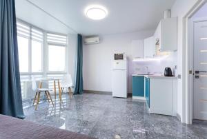 基辅Апартаменти "Kopernik"的一间厨房,配有白色家电和桌椅