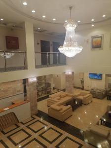 Al Ḩalaqahلوس للشقق المفروشة的带沙发和吊灯的客厅