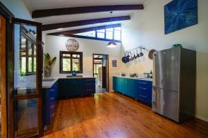 苦难角怀尔德伍德度假屋的厨房配有蓝色橱柜和不锈钢冰箱