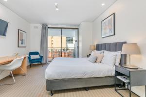 珀斯All Suites Perth的一间卧室配有一张大床、一张桌子和一张书桌