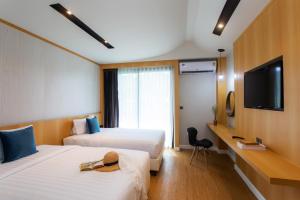 查汶The Canale Samui Resort - SHA Extra Plus的酒店客房设有两张床和一台平面电视。