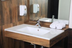 罗纳瓦拉Hotel Planet Four的浴室配有盥洗盆、镜子和毛巾