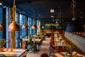 沃卡蒂维卡提索考斯公寓式酒店的餐厅设有木桌和椅子以及大窗户。