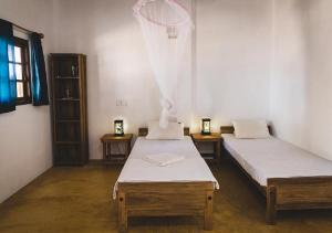 卡尔皮蒂耶Surfpoint Sri Lanka Kite Village的一间设有两张床的房间和篮球架