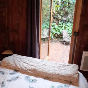 维列莫尔贡Foudres du Chêne du Py的一间卧室设有一张床和一个滑动玻璃门