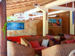 迭戈苏瓦雷斯Hotel Lakana Ramena的一间设有藤椅和红色沙发的房间