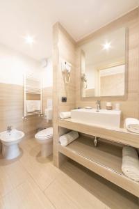博尔迪盖拉Gold Hotel的浴室配有盥洗池、卫生间和镜子。