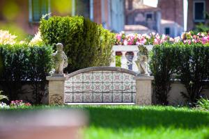 威尼斯Ca' dei Cuori on the Grand Canal的花园中设有雕像的围栏