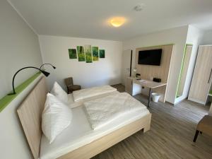 拉德贝尔根埃斯彭霍夫汽车旅馆的卧室配有白色的床和电视。