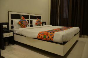 阿姆利则Hotel KK Continental 50 Meter from Railway Station - Amritsar的一间卧室配有一张大床和色彩缤纷的毯子