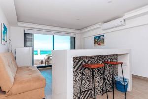 坎昆Villas Marlin 108, a pie de playa, albercas, jacuzi, ubicacion inmejorable的客厅配有沙发和桌子